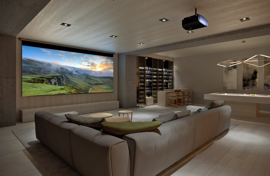 Home movie theater with sectional seating, projector and screen.