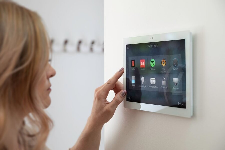 A woman utilizing a smart touchscreen with a professional home network connection.